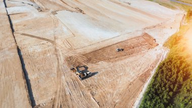Büyük toprak sahada çalışan inşaat araçları
