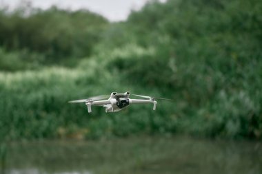 Açık havada, yeşil alanda uçan drone.