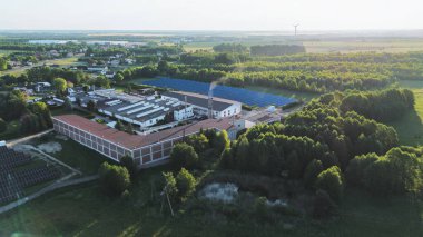 Günbatımında rüzgar ve güneş enerjisinden yararlanan sürdürülebilir bir endüstriyel tesis manzarası