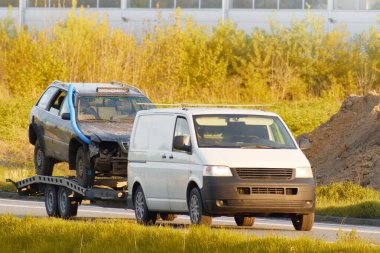 Römorkta iki hurda araba taşıyan çekici.