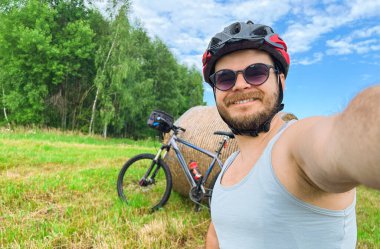 Bisikletçi Saman ve Ağaçlarla çevrili Tarlada Selfie Çekiyor