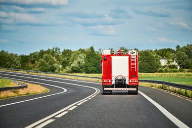 İtfaiye aracı banliyö yakınındaki yolda ilerliyor.