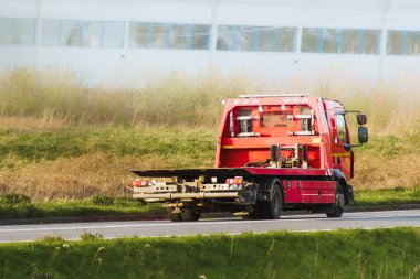 Kırsal kesimde gün batımı otoyolunda giden turuncu çekici.