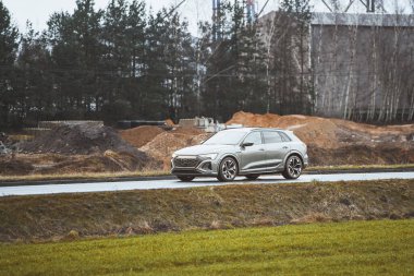 Kırsal kesimde ağaçlar ve inşaat ile modern SUV