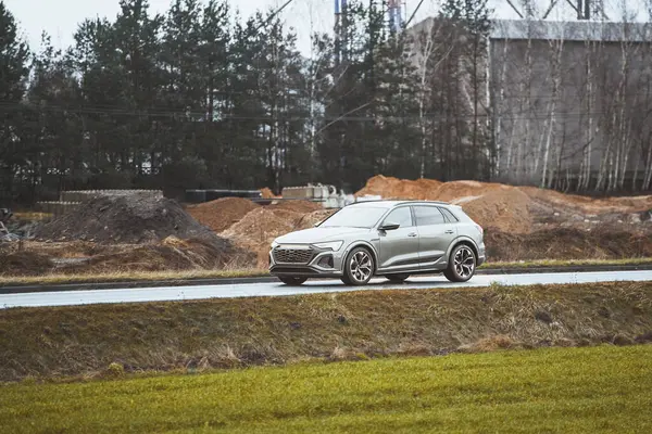 Kırsal kesimde ağaçlar ve inşaat ile modern SUV