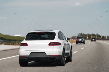 Boş bir otoyolda beyaz bir SUV sürüyordu..