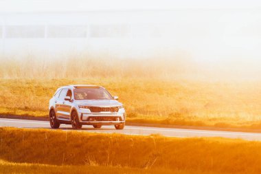 Elegant black SUV driving through scenic green countryside clipart