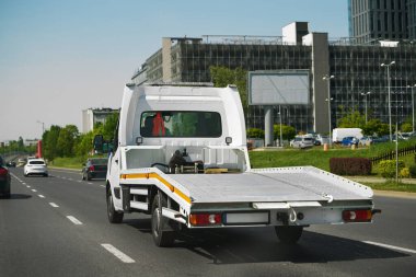 Flatbed kamyonu şehir yolunda sürüyor