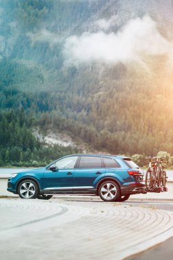 Avrupa 'da gölün yanından geçen arka montajlı motosikletli modern SUV