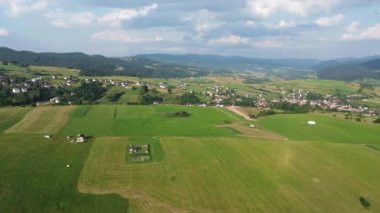 Arka planda yeşil tarlaları ve dağları olan manzaralı bir yer.