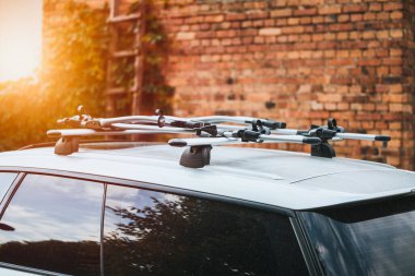 Car roof with bike rack set for a trip at sunset clipart