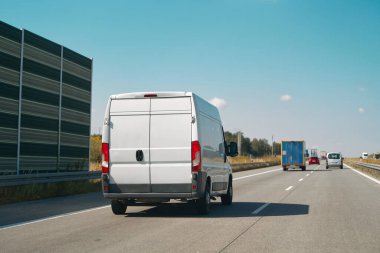 Otoyol trafik sahnesinde beyaz minibüs