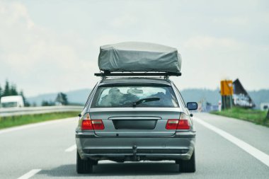 Çatı çadırı olan eski bir araç otoban boyunca gidiyor.