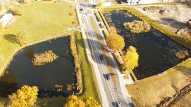Yakınlarda su birikintileri olan kırsal alan yolu.