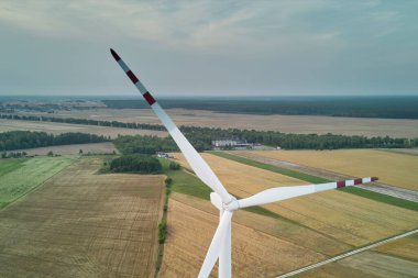 Yeşil alanlar ve mavi gökyüzü arasındaki rüzgar türbini manzarası