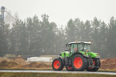 Modern yeşil traktör kırsal sisli yolda sürüyor