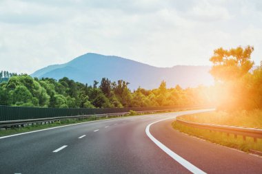 Araçlar bulutlu gökyüzünün altında otoyolda ilerliyor