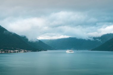 Gemi yeşil dağ ve köyden geçiyor.