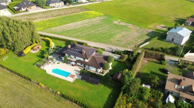 Lüks bir evin insansız hava aracı görüntüsü, bahçeli, yemyeşil bir ormana kurulmuş, doğa ve mimariyi harmanlayan..