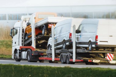 Sarı kamyon otobanda beyaz minibüs taşıyor.