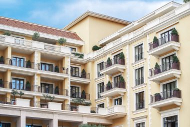 Zarif balkonları ve pencereleri olan sarı bina.