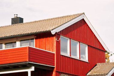 Beyaz süslemeli ve pencereli İskandinav kırmızı evi