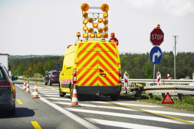 Yol yapım aracı ve dur işareti görünür