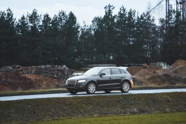 Kırsal yolda yemyeşil zemini olan güvenli aile cipi.