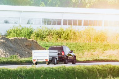 Araç yolda küçük bir römorku çekiyor.