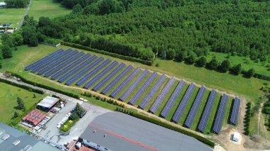 Kendini adamış bir güneş enerjisi santrali ile donatılmış endüstriyel üretim tesisinin havadan görüntüsü.