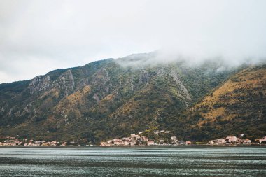 Sakin deniz kenarında alacakaranlıkta görkemli dağ manzarası