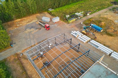 Makine ve çelik çerçeveli bir inşaat alanının havadan görüntüsü