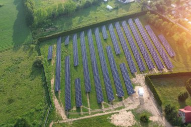 Güneş panellerinden güç alan modern evlerin havadan görünüşü yeşil çimlere bitki örtüsü yerleştiriyor.
