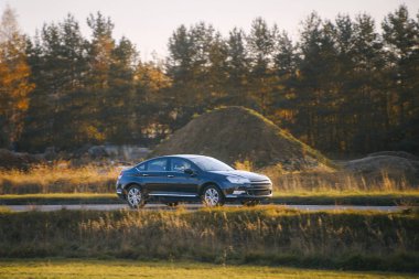 Çimenli arazide modern araba sürüyor.