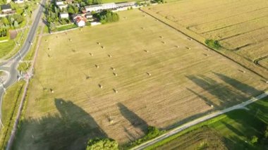 Gün batımında saman balyaları olan kırsal bir yer.