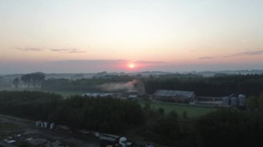 Güneşin doğuşunda saman balyalarıyla puslu çiftlik alanı