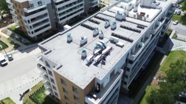 Modern bir apartmanın çatısına iklim kontrolü ve yenilenebilir enerji sağlayan Hvac ekipmanları ve güneş panelleri kurulmuştur.