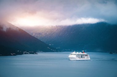 Gemi yeşil dağ ve köyden geçiyor.