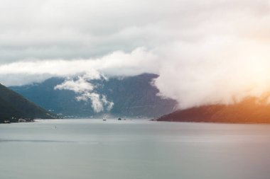 Yeşil fiyort körfezinin üstündeki dağ tepelerini kaplayan sis.