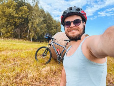 Güneşli bir günde Bisikletli Adam Tarlada Selfie Çekiyor