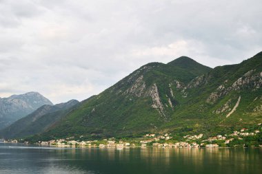 Gün batımında sakin koyda engebeli dağ yamaçları