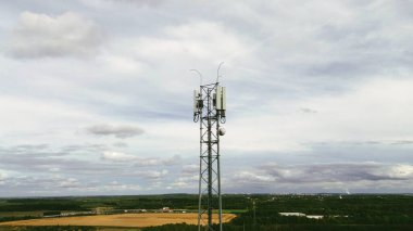 Bulutlu kırsal manzaranın ortasında uzun sinyal kulesi