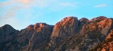 Parlak mavi gökyüzünün altında etkileyici dağ zirveleri