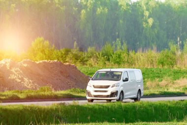 Kırsal bir yolda yeşil bir minibüs.