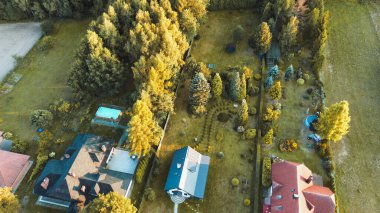 Ormanla çevrili lüks bir evin havadan görünüşü.