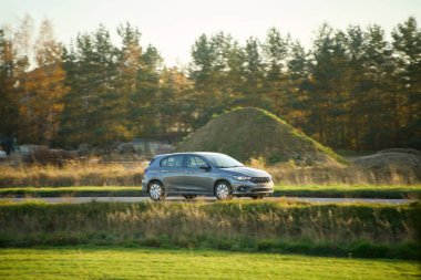 Açık kırsal yolda gümüş bir araba.
