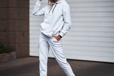 Beyaz kapüşonlu ve eşofmanlı tanınmayan bir kadın.