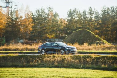 Kırsal yolda siyah bir araba.