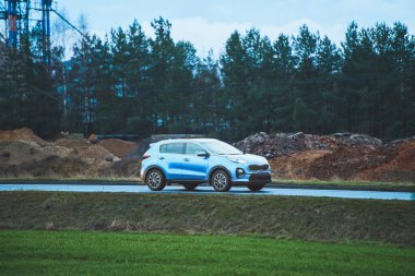 Kırsal kesimde ağaçlar ve inşaat ile modern SUV