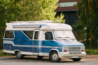 Yeşillik bir orman bölgesinde park etmiş bir karavan.